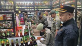 Satpol PP Kota Depok saat menyita miras berbeagai merek dari pedagang jamu tradisional di kawasan Sawangan, Depok. (Dokumen Satpol PP)