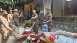 Satpol PP Kota Depok mengevakuasi barang saat penertiban bangunan liar di Jalan Raya Juanda, Depok. (Dicky)
