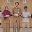 Plt Lurah Duren Mekar, Supriyadi memperlihatkan PMT pangan lokal yang diberikan kepada ibu hamil dan balita.