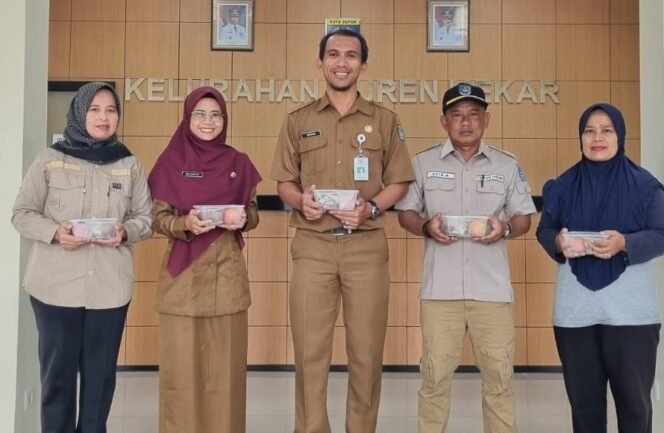 
					Plt Lurah Duren Mekar, Supriyadi memperlihatkan PMT pangan lokal yang diberikan kepada ibu hamil dan balita.