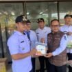 Caption : Camat Bojongsari, Rijal Farhan menyerahkan secara simbolis makanan bergizi kepada Lurah Pondok Petir, Rengga Nugraha untuk diserahkan kepada balita dan anak, di kantor Kelurahan Pondok Petir, Bojongsari, Depok. (Rahcmat)