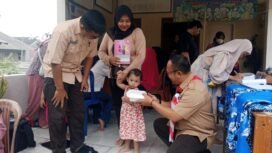 Camat Bojongsari, Rijal Farhan bersama Lurah Pondok Petir, Rengga Nugraha saat memberikan makanan tambahan kepada balita di Posyandu Rose, Pondok Petir, Bojongsari, Depok. (Rahcmat CH)
