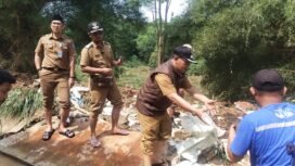 Camat Bojongsari, Rijal Farhan bersama Lurah Pondok Petir, Rengga Nugraha membantu membersihkan tanggul yang jebol di Perumahan Villa Pamulang, Pondok Petir, Bojongsari, Depok. (Rahcmat)
