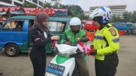 Anggota Satlantas Polres Metro Depok bersama selebgram Nabila Putri membagikan bendera merah putih di Terminal Terpadu Depok. (Dicky)