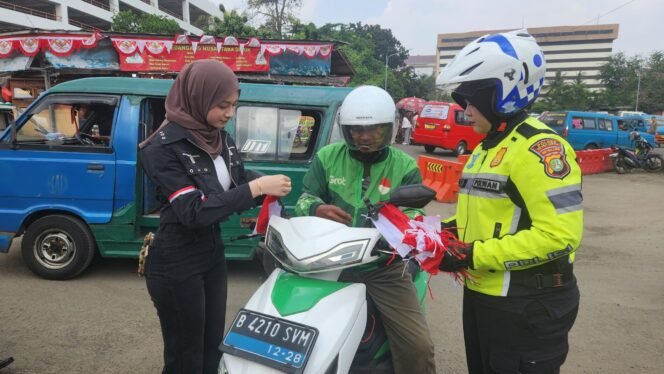 
					Anggota Satlantas Polres Metro Depok bersama selebgram Nabila Putri membagikan bendera merah putih di Terminal Terpadu Depok. (Dicky)