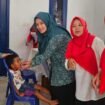 ‎Ketua TP Posyandu Kecamatan Bojongsari, Novi Susanti saat memberikan vitamin A kepada balita.