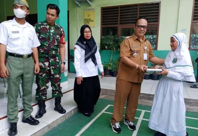 
					Camat Bojongsari, Rijal Farhan saat memberikan makanan dari program MBG di MI Miftahul Huda, Pondok Petir, Bojongsari, Depok.