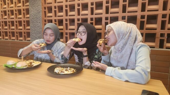 
					Caption : Pengunjung saat menikmati Pizza dan Burger daging rendang di Kemuning Resto, Cilodong, Depok. (Dicky)