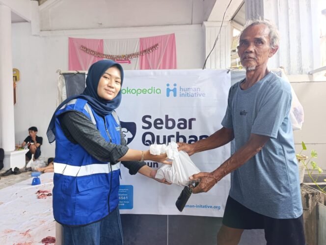 
					Caption : Perwakilan Human Initiative saat memberikan daging kurban kepada masyarakat di wilayah Depok.